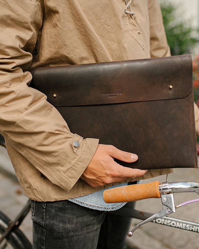 stillvolle Laptoptaschen aus Leder gehalten von einem männlichen Model.