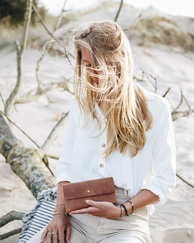 weibliches Model mit einer Geldbörse für Damen aus Leder.